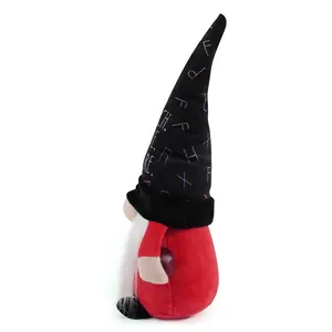 Side view of a teacher's day themed gnome doll with a tall black alphabet print hat