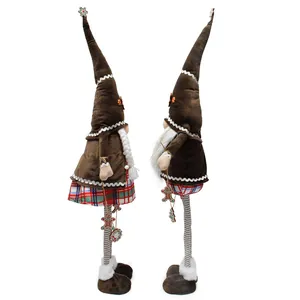 Side view showing two tall plush gingerbread gnomes with festive hats and ornaments.