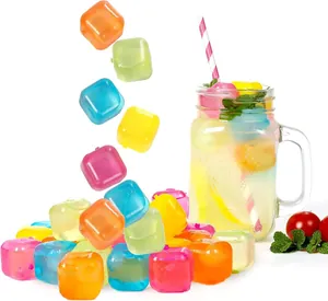 Gros plan de glaçons en plastique réutilisables colorés tombant dans une boisson
