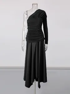 Elegant black one-shoulder ruched dress with asymmetrical hemline and single long sleeve.
