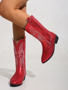 Vue détaillée de bottes de cowboy rouges métallisées avec broderie d'ailes et bout pointu