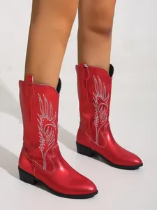 Gros plan de bottes de cowboy rouges métallisées avec broderie flamme blanche et talon carré