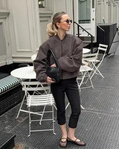 Detailweergave van een vintage grijs suède kort jack voor dames in een minimalistische zip-stijl