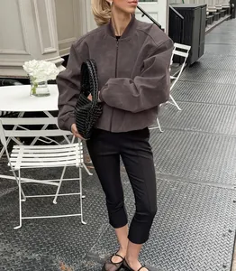 Model in een vintage grijze suède bomberjack in een minimalistische streetstyle setting.