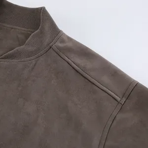 Detailopname van een grijs suède jack met hoogwaardige stiksels en zachte textuur.