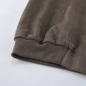 Detailopname van grijs suède jack met geribbelde manchetten en zachte textuur