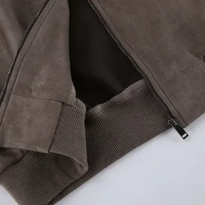 Macrodetail van grijs suède jack met soepele rits en geribbelde zoomafwerking luxe.