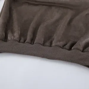 Detailopname van de elastische geribbelde zoom van een grijze vintage suède jas met textuur