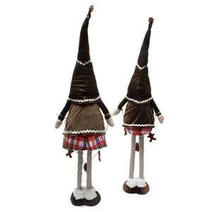 Detailed view of standing gingerbread gnomes with tall hats and plaid skirts for Christmas.