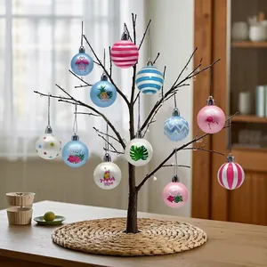 Tropische Flamingo- und Palmblatt-Kugel-Anhänger an einem schwarzen Deko-Baum.