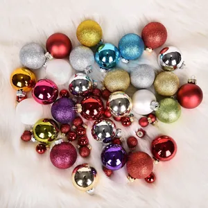 Detailed view of assorted colorful Christmas baubles on a white faux fur background