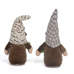 Detalle de dos gnomos de café marrones con sombreros de punto y cuadros escoceses