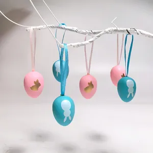 Vista detallada de huevos de Pascua de plástico azul y rosa con diseños de conejo en una rama