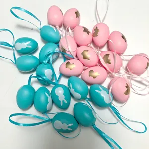 Vista detallada de huevos de Pascua de plástico de 4 cm azules y rosas con conejos.