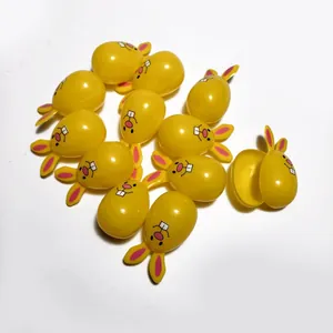Multiple yellow plastic Easter bunny-shaped candy eggshells showing one openable shell detail