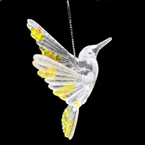 Nahaufnahme eines transparenten Kolibri-Anhängers aus Acryl mit goldenen Pailletten für Weihnachten