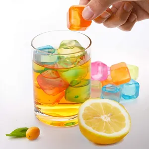 Glaçons en plastique colorés réutilisables dans un verre à boisson avec détail de citron frais