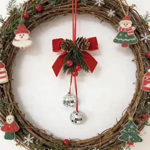 Detailed view of a Christmas wreath featuring a red velvet bow, pinecones and mirror balls