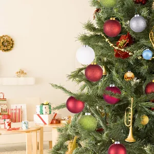 Detailed view of assorted colorful Christmas baubles hanging on a festive tree