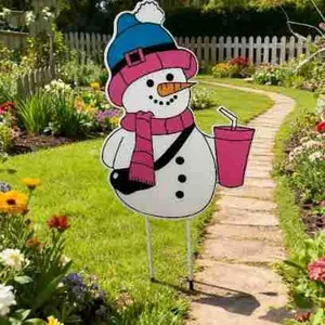 Piquet de jardin bonhomme de neige festif en fer sur une pelouse dans un jardin ensoleillé.