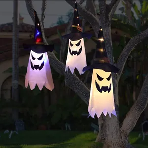 Detailansicht von drei leuchtenden Halloween-Geist-Windsäcken mit Hexenhüten im Freien.