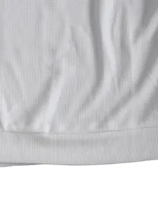 Detailansicht der weißen, schweren Waffelstrick-Struktur eines Langarm-T-Shirts.
