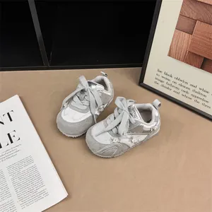 Close-up view of silver girls' sneakers featuring cute bowknots and pearl accents.