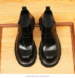 Vista detallada de los botines Chelsea en charol negro con suelas retro gruesas
