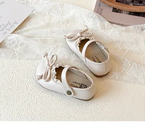 Vista dettagliata delle scarpe Mary Jane beige per bambini con fiocco e pizzo dolce