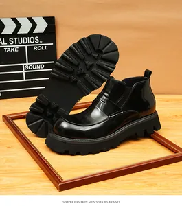 Vista detallada de botines Chelsea negros brillantes para hombre con suela gruesa.