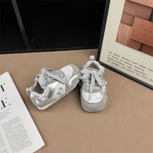 Detailed view of stylish grey girl's sneakers featuring elegant pearl bow embellishments