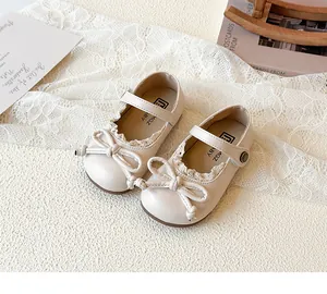 Dettaglio di bebè color crema per bambine con bordo in pizzo e fiocco decorativo