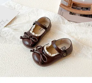 Vista dettagliata delle scarpe Mary Jane marroni per bambina con fiocco a farfalla e pizzo