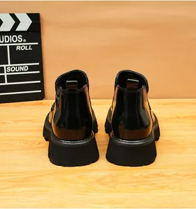 Vista trasera detallada de botines Chelsea negros brillantes para hombre con suela gruesa