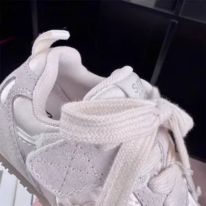 Close-up of girls sports shoe featuring a stylish knit bow shoelace and suede texture.