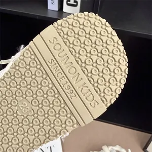 Macro view of non-slip rubber sole for kids sneakers featuring beige circular patterns