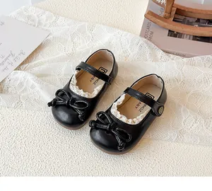 Dettaglio di scarpe da principessa nere con finiture in pizzo e fiocco per bambine