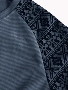 Nahaufnahme aus schwerem Waffelstrickgewebe mit geometrischem Raglanärmel-Druck
