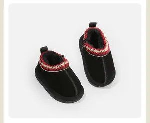 Close-up of black toddler snow boots featuring festive embroidered trim and cozy fur interior