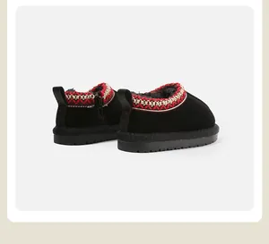 Close-up of children's black warm snow boots with red ethnic embroidery trim and thick sole