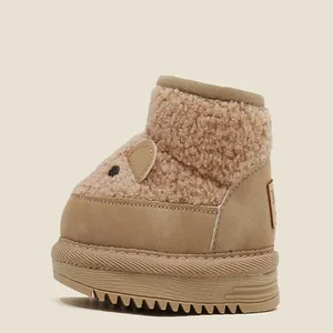 Close-up detail of warm children's snow boots with cute bear ears and fleece lining