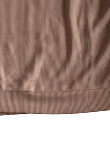 Nahaufnahme von schwerem Waffelstrickstoff und Rippsaum an braunem Herren-T-Shirt
