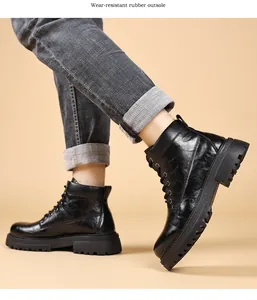 Primer plano de botas de trabajo de cuero negro para hombre con suela de goma robusta.