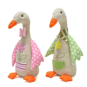 Vue détaillée de deux ornements d'oie en tissu avec des ailes à pois colorées.