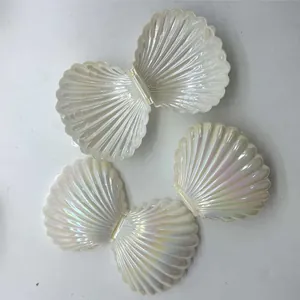 Dettaglio di scatole per bomboniere a forma di conchiglia bianco perla cangiante, aperte e chiuse