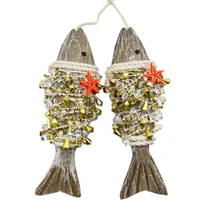 Detailed view of two hanging wooden fish ornaments with gold beads and orange starfish.