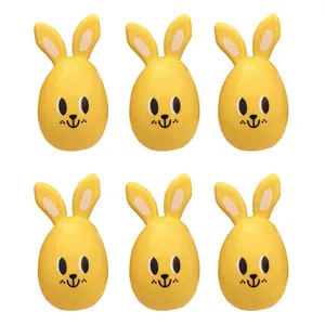 Six yellow Easter bunny egg-shaped candy containers arranged in two rows on white.