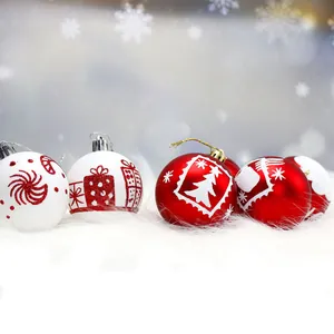 Close-up van handgeschilderde rode en witte glitter kerstballen op een sneeuwachtige ondergrond