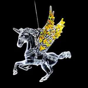Makrodetail eines transparenten Acryl-Einhorn-Anhängers mit glänzenden Goldpailletten