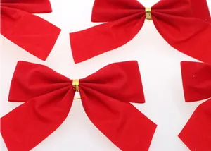 Detailed close-up view of red velvet Christmas bows with elegant gold wire center tie